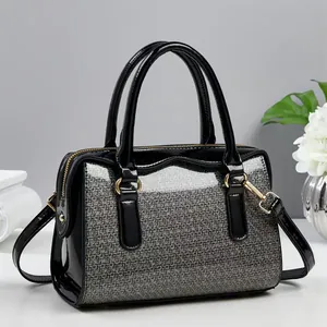 Elegant black patent leather boston bag with silver glitter texture and golden hardware