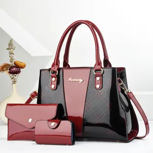 Close-up of a 3-piece set featuring patent leather tote and clutch with gold hardware
