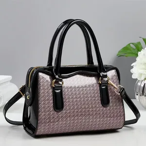 Detail view of purple sequin woven pattern and black patent leather on the handbag