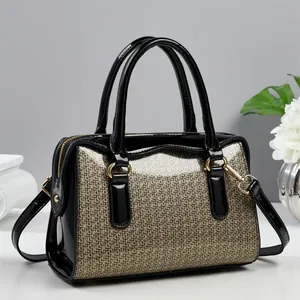 Detail of the Boston bag showing sparkling gold fabric and black patent leather trim finish