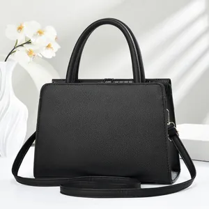 Detail of black lychee texture tote bag with golden hardware on a minimalist background