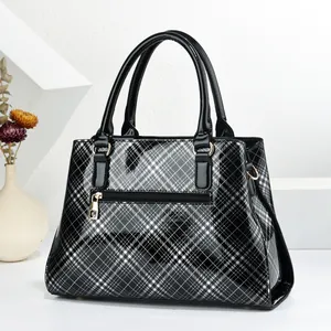 Detail of retro black and white plaid tote bag with glossy leather finish and metal zipper