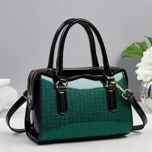 Detail of dark green sequin Boston bag with glossy black patent leather and gold hardware