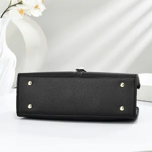 Close-up of black crocodile pattern tote bag base with gold metal protective feet