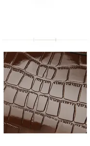 Close-up of deep brown embossed crocodile texture on premium PU leather handbag