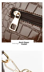 Detail of brown crocodile embossed leather bag with back zipper pocket and gold hardware