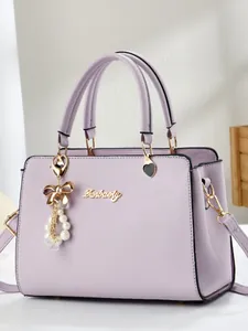 Elegant lavender faux leather handbag with golden hardware and pearl bow pendant charm