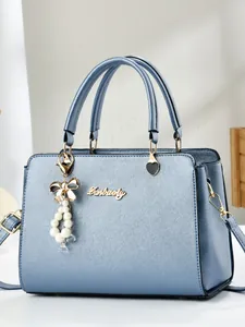 Elegant light blue cross-textured handbag with pearl pendant and adjustable strap