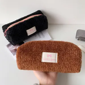 Close-up of plush fuzzy pencil case with pink zipper and Lucky Gate logo detail