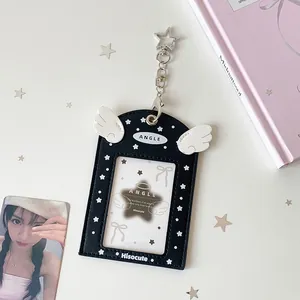 Detail of black PU photo card holder with white angel wings and silver star keychain