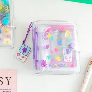 Detail of 3-ring mini PVC photo album with purple bear patterns and game console charm