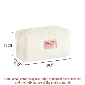 White plush makeup bag with pink patch and metal zipper for winter toiletries