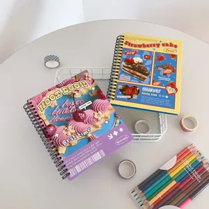 Flat lay of cake themed spiral notebooks with double-ended colored pencils on a desk