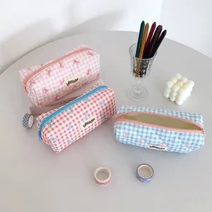 Quilted plaid pencil case in cream colors with ribbon accent and top zipper closure