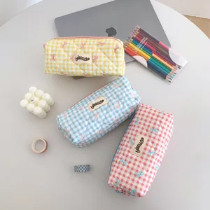 Detailed view of quilted grid pencil cases with cute bows in yellow, blue and pink