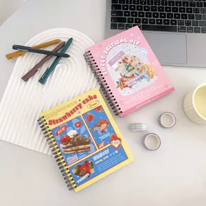 Flat lay of pink and yellow spiral notebooks with cute cartoon dessert cover designs