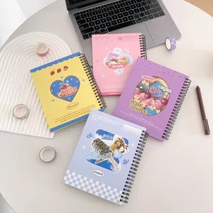 Flat lay of four colorful dessert-themed spiral notebooks with stationery on a white desk