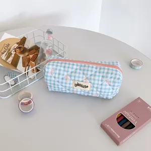 Detailed view of blue checkered pencil case with embroidered pink bow and top zipper