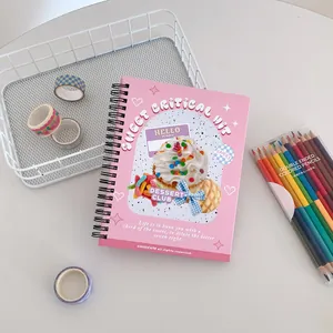 Detail of pink coil notebook featuring sweet dessert illustrations and metal spiral binding