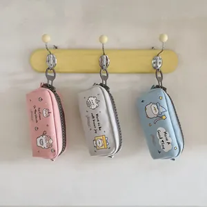 Dettaglio di astucci in tela con stampe di animali e chiusure a zip in plastica resistente