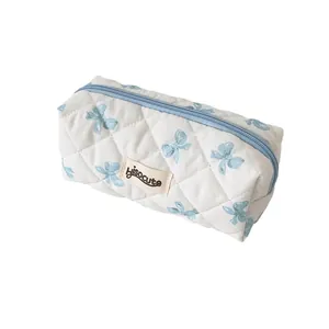 Quilted cream pencil case with blue bow patterns and zipper, cute stationery bag