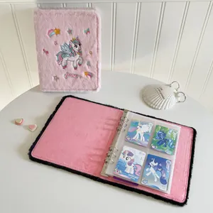 Pink plush A5 binder with unicorn embroidery showing clear 4-pocket interior card sleeves