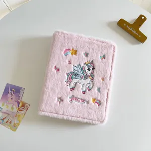Detailed view of pink plush A5 binder cover with unicorn embroidery and Secret text