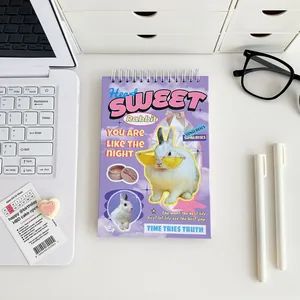 Flat lay of purple coil weekly planner with white rabbit design and desk accessories