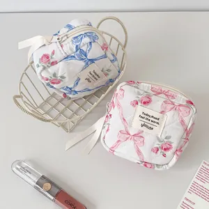 Floral quilted cosmetic pouches with pink roses, blue bows and ribbon zipper pulls