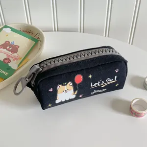 Dettaglio dell'astuccio in tela nera con stampa Corgi e cerniera in plastica spessa