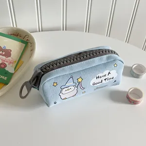 Dettaglio dell'astuccio in tela azzurra con pulcino cartone e grande cerniera grigia lampo