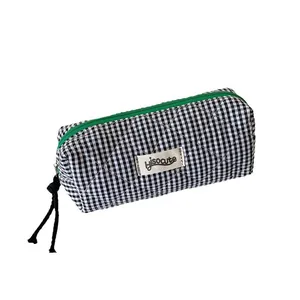 Quilted black and white checkered pencil case with vibrant green zipper closure