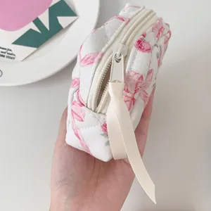 Detailed macro view of quilted floral cotton makeup bag with ribbon zipper puller