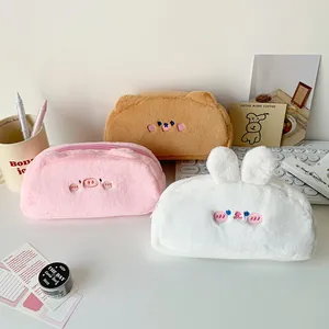 Cute plush animal pencil cases in pig bear and rabbit shapes on desk setup