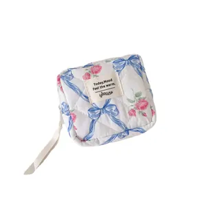 Quilted floral makeup bag with pink roses and blue bows for portable storage