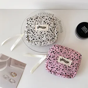 Quilted ink splatter mini makeup bag with decorative ribbon and HisoCute brand label