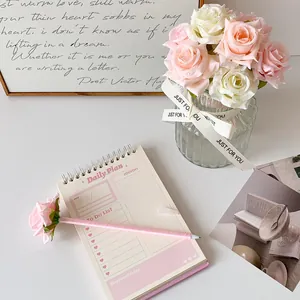 Gros plan d'un carnet de notes quotidien avec liste de tâches et stylo rose créatif