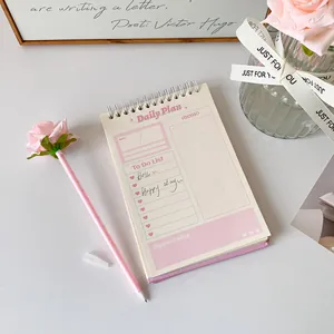 Gros plan d'un agenda journalier avec liste de tâches et stylo créatif en forme de rose