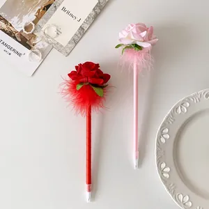 Detailed view of artificial rose flower ballpoint pens with feathers and silk ribbon wrap