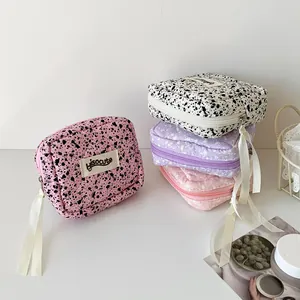 Quilted fabric pouches with splatter pattern and elegant long ribbon zipper pull detail