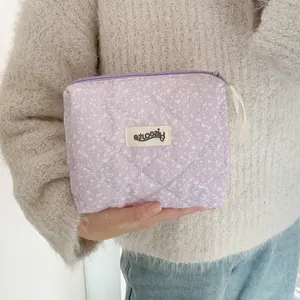 Close-up of lavender quilted makeup bag with ink splash texture and purple zipper