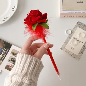 Detail of red artificial rose ballpoint pen with feather accents for gift decor