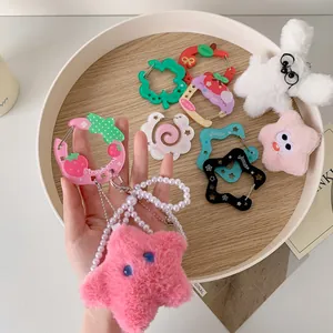 Close-up of colorful acrylic carabiner hooks, plush stars and pearl charms for bags
