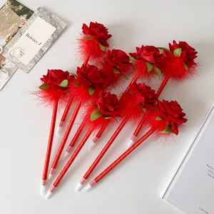 Detail of red rose pens with silk flowers and feathers arranged in a decorative fan shape