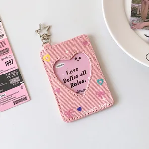 Macro shot of pink denim photocard holder with heart window and star-shaped keychain hook