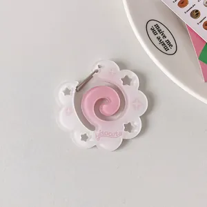 Macro view of pink flower-shaped acrylic carabiner keychain with spiral heart and star details