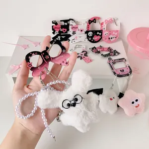Detail view of plush puppy keychain with glasses and gradient heart carabiner