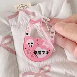 Detailed shot of pink acrylic skull heart keychain with peeling protective film