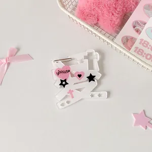 Macro detail of acrylic 'Love' heart brooch with cute star and cross motifs