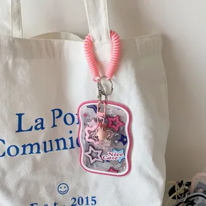 Roze sterren-kaarthouder met spiraalkoord en sterhanger aan een canvas tas